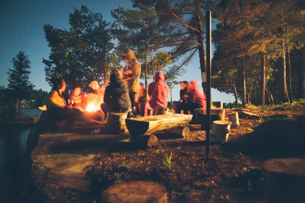 Family and friends at a lakeside campfire in Muskoka Lakes