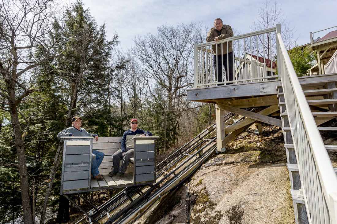 The Cottage LIfts elevation solutions team sitting on one of their Muskoka cottage lifts